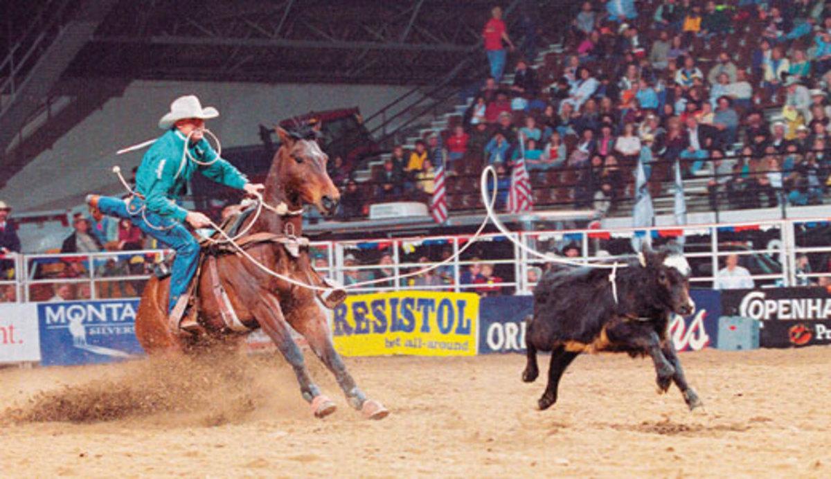 Brent Lewis dismounts during a calf roping run with a bridleless horse