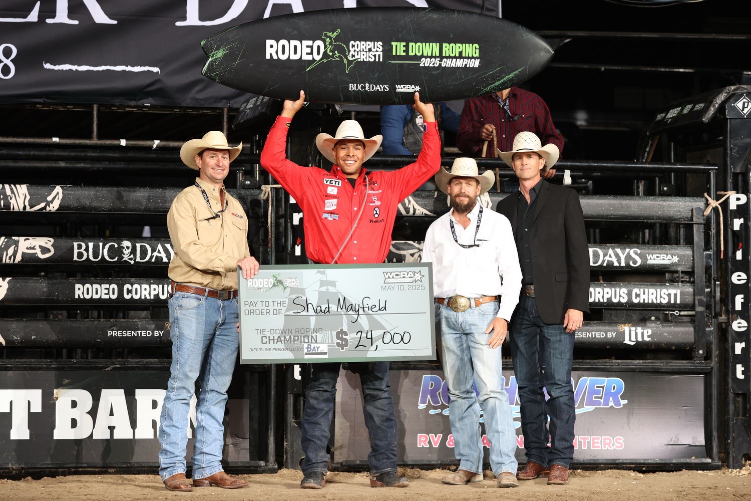 Shad Mayfield holds up Rodeo Corpus Christi champion prizes